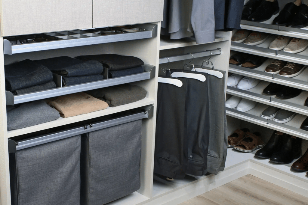 A walk in closet with a lot of clothes and shoes.