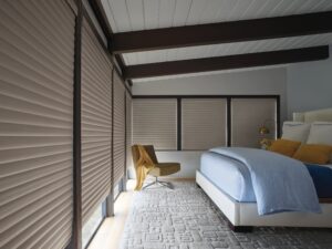 Taupe colored bedroom with wraparound windows that has Sonnette Cellular Roller Shades installed