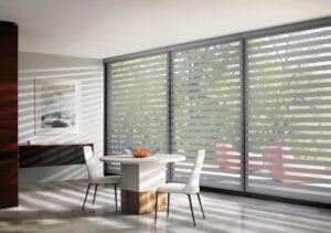 Small dining room with a table and 3 windows with Designer Banded Shades installed