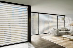 Multiple floor to ceiling windows in a big living room that have Designer Banded Shades installed