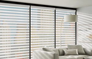 Living room with a sectional in front of a window with Designer Banded Shades insatlled