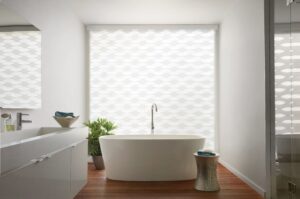 Bathroom with a big tub in front of a window with Designer Banded Shades installed