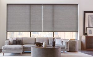 Triple bay window above a couch in a living room with Designer Roller Shades installed