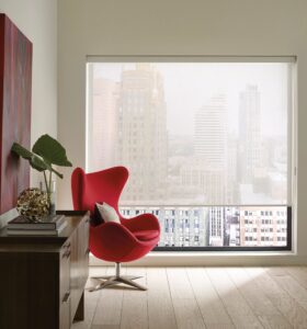 Red chair in the corner of an office with a big window with Designer Screen Shades