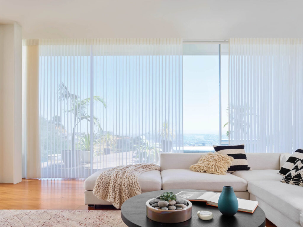 A living room with white furniture and a view of the ocean.