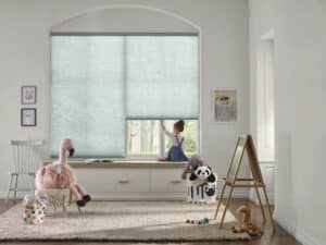 Child playing in playroom with Hunter Douglas Applause honeycomb shades in the background