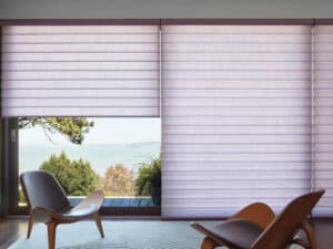 Two chairs in a bedroom with Pirouette® Sheer Shades on window