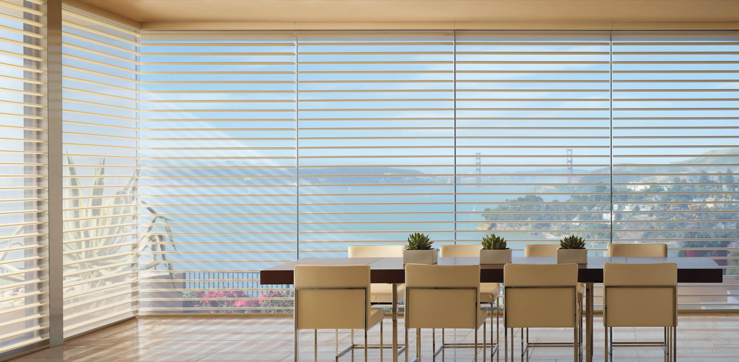 A dining room with blinds and a view of the ocean.