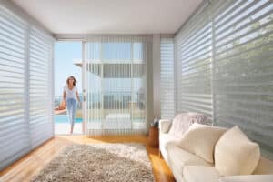 Lady walking into sunroom covered with Silhouette® Window Shadings