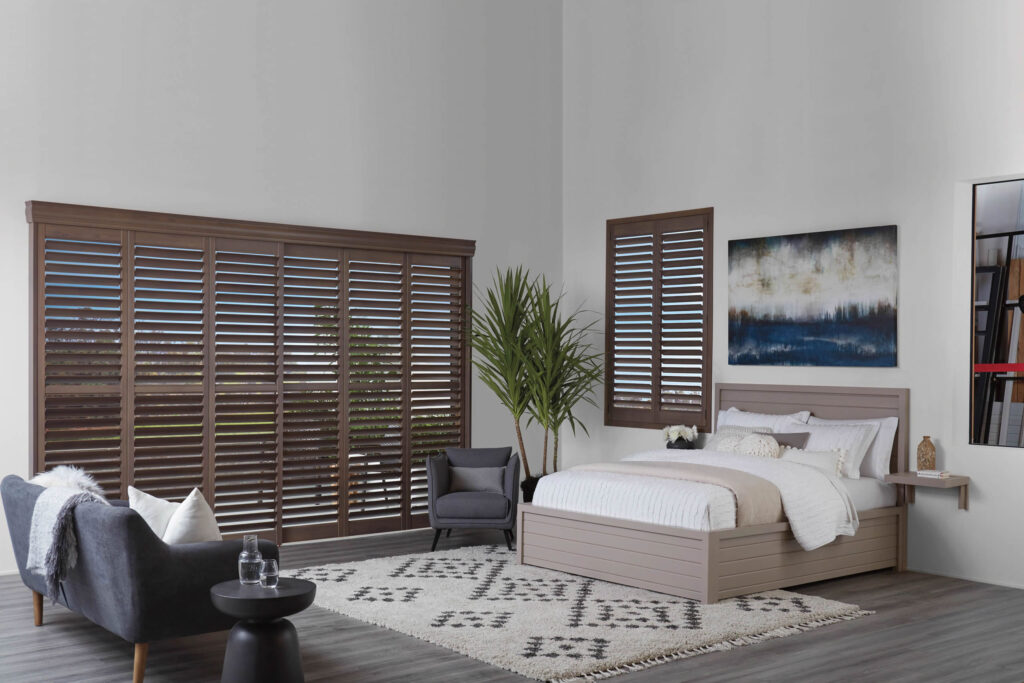 Patio doors located in the bedroom covered with Hunter Douglas Shutters