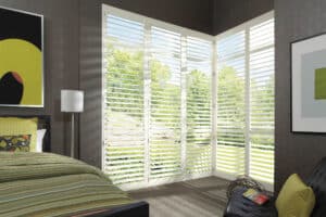 Bedroom with corner windows covered with NewStyle Hybrid Shutters