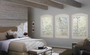 White coloured bedroom with split windows adorned with NewStyle Hybrid Shutters