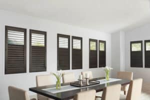 Dining room with mulitple windows covered in NewStyle Hybrid Shutters