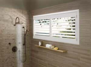 Widnow in bathroom shower covered with Palm Beach Polysatin Shutters
