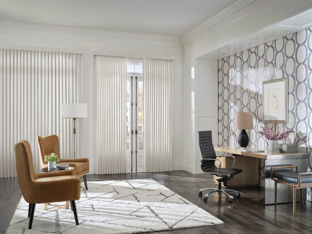 An office with two chairs and a desk near patio door with Hunter Douglas vertical blinds
