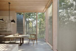 A dining room with a wooden table and wooden blinds.