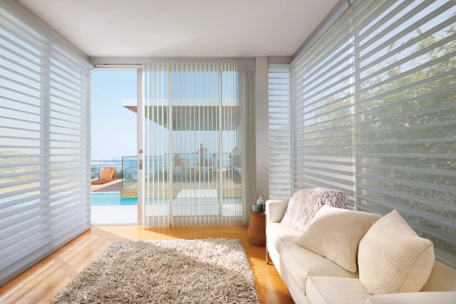 A living room with a patio door covered by blinds.