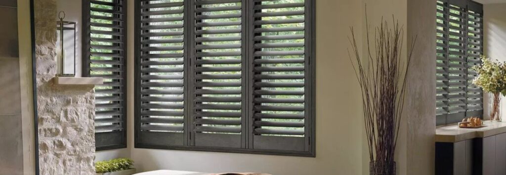 A bathroom with wood shutters in the window.