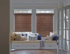 A room with venetian blinds and a window seat.