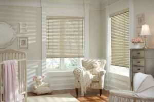 A baby's room with white venetian blinds and a white crib.