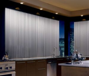 A kitchen with stainless steel appliances, a large window, and Hunter Douglas Somner vertical blinds.
