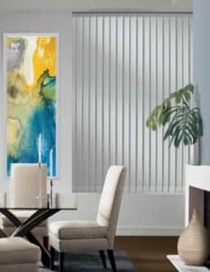 A dining room with a large painting on the wall, adorned with Hunter Douglas Somner vertical blinds.