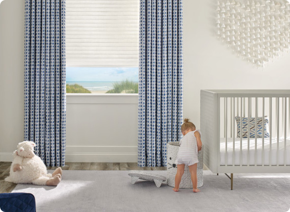 A child's room with blue and white drapery and a teddy bear.